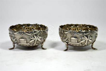  A pair of Indian silver salt pots, decorated with huts and palms