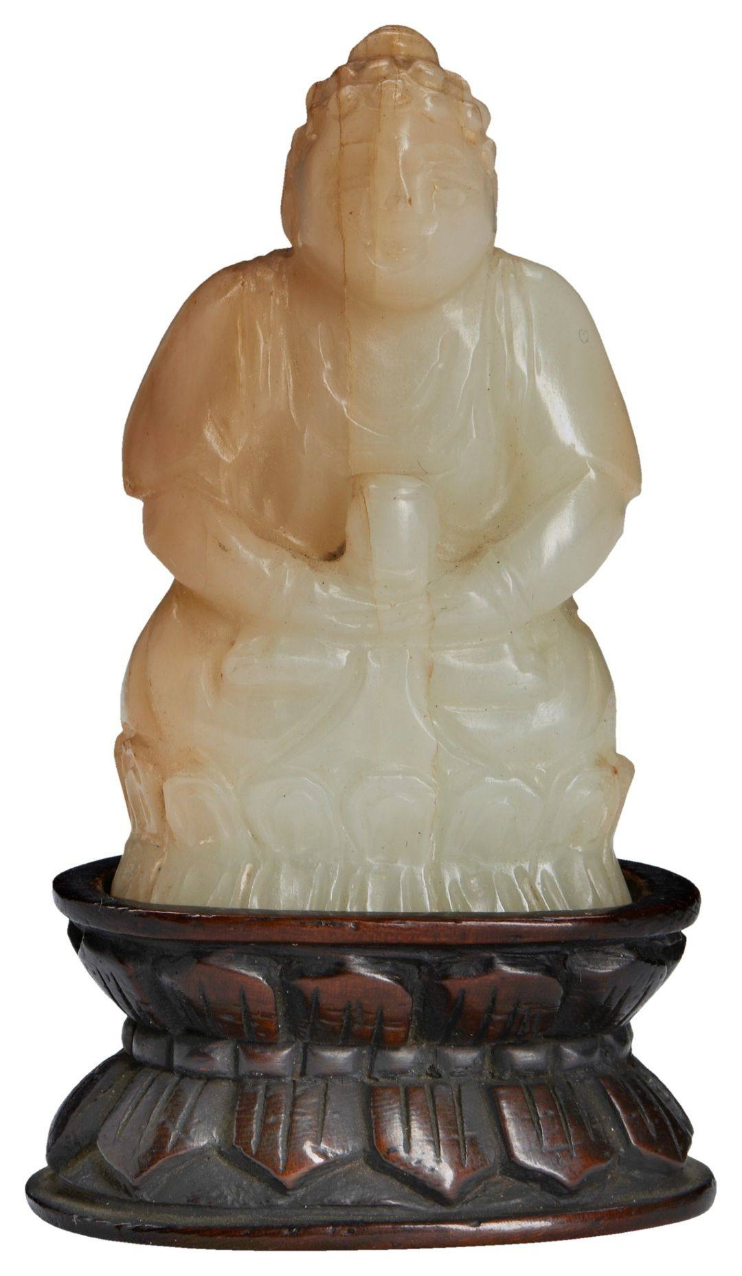 A SMALL CARVED PALE-GREEN JADE BUDDHA QING DYNASTY (1644-1911) 玉雕佛像及木座 清 seated in dhyanasana,