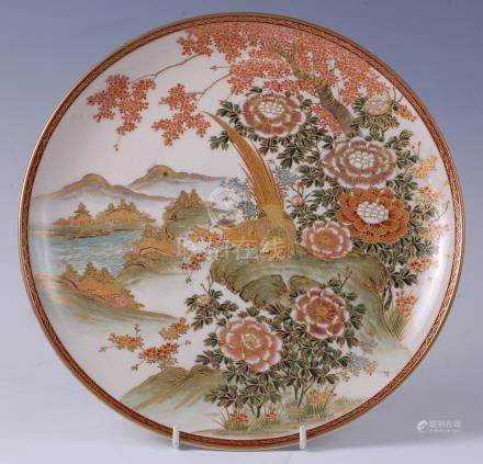  A Japanese satsuma charger, decorated with exotic birds amidst prunus blossom and a landscape,