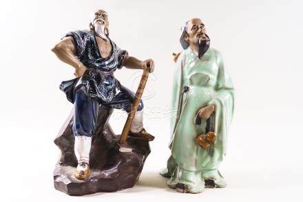  Two Chinese Shiwan (mud man) figures, one standing on a rocky base with an axe