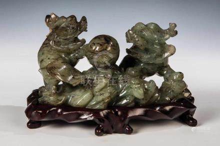  Zwei Fo Hunde mit KugelChina, wohl 20. Jahrhundert Jade auf Holzsockel. H. 8 cm. Min. best.Two Foo