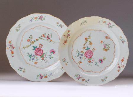 Pareja de platos en porcelana, "familia rosa", decoración con grupo de grandes flores a un lado en