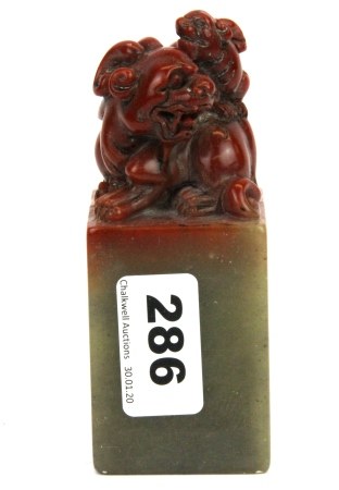 A Chinese mixed colour carved soapstone scholars seal mounted with a dragon and baby, H. 12cm.