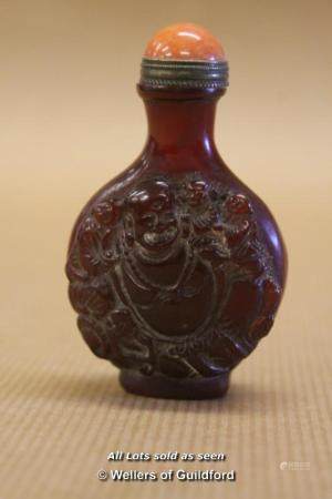 A Chinese hardstone snuff bottle carved with Buddha and a monkey.