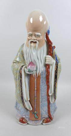 A modern Chinese porcelain figure, modelled as Shou Lao, the god of longevity, standing holding a