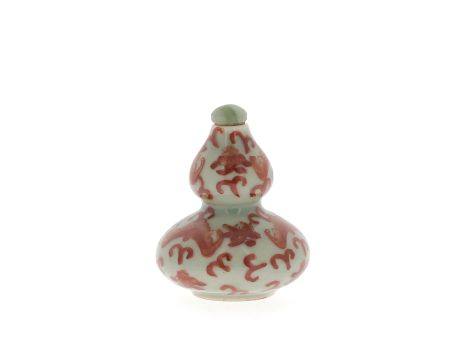 CHINE, XXe siècle
Petite tabatière en porcelaine
à décor de chauves souris en rouge de fer sur 