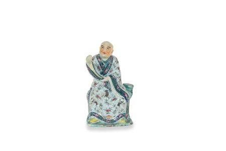 CHINE, XIXe siècle
Personnage en porcelaine assis sur un rocher
et vêtu d’une robe à décor de p