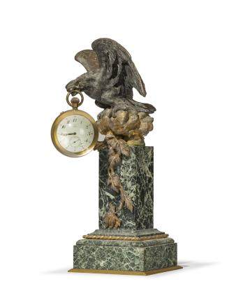 Porte montre d'époque Napoléon III, en bronze doré et patiné figurant un aigle, dans son bec une pendulette Omega, base en marbre vert,h. 37 cm 