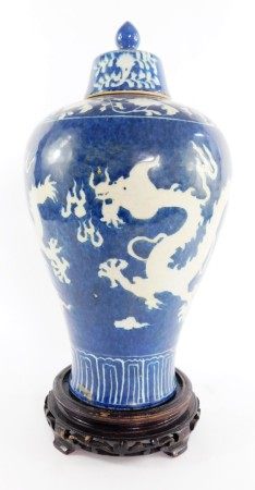 A Chinese porcelain baluster vase and cover, decorated with white Imperial dragons chasing a flaming