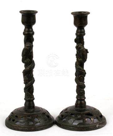  A pair of 19th century Chinese bronze candlesticks, the columns decorated with a coiled dragon,